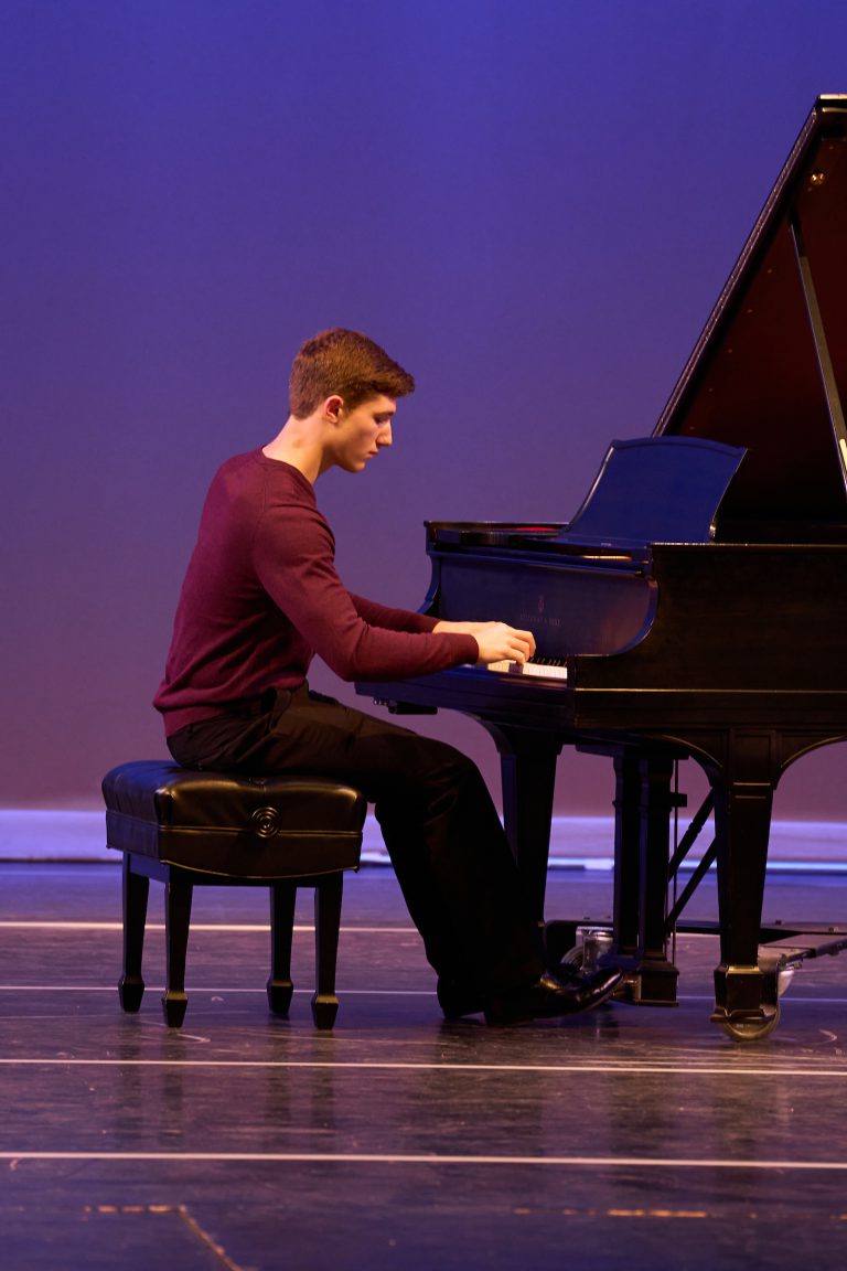 boy playing piano on stage